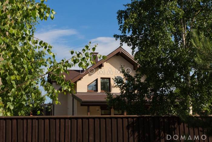 Проект дома из кирпича с угловой террасой и просторным балконом на мансардном этаже