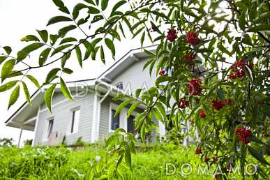 Проект дома из пеноблоков с навесом для машины и двумя спальнями на мансардном этаже