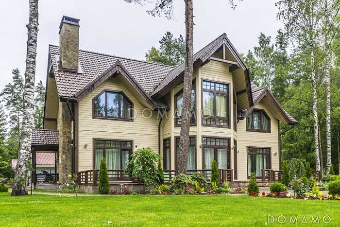 Проект коттеджа из газобетона с мансардой, эркером, светлой гостиной и открытой террасой